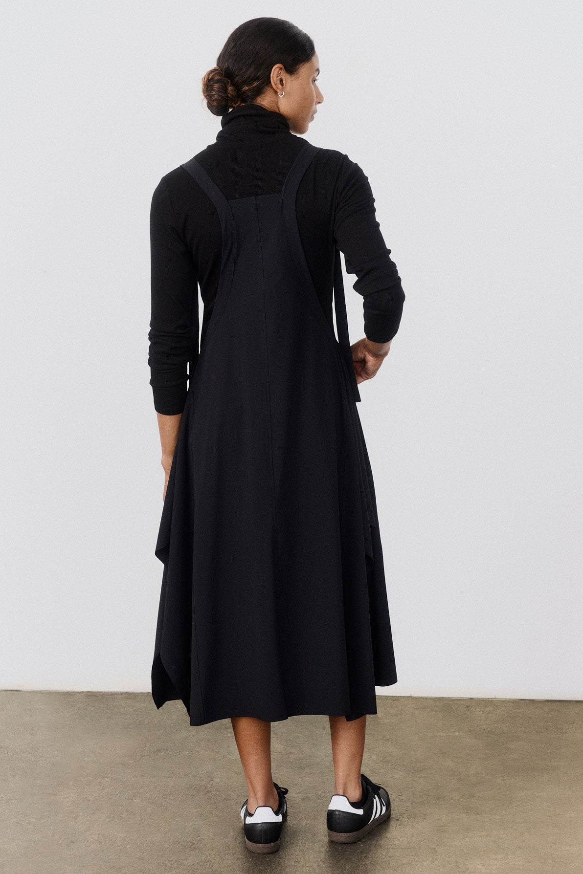 Black sleeveless sarafan dress with crisscross back strap and flared midi hem.