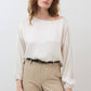 Ivory silk blouse with scoop neck, long puff sleeves, and cinched hem