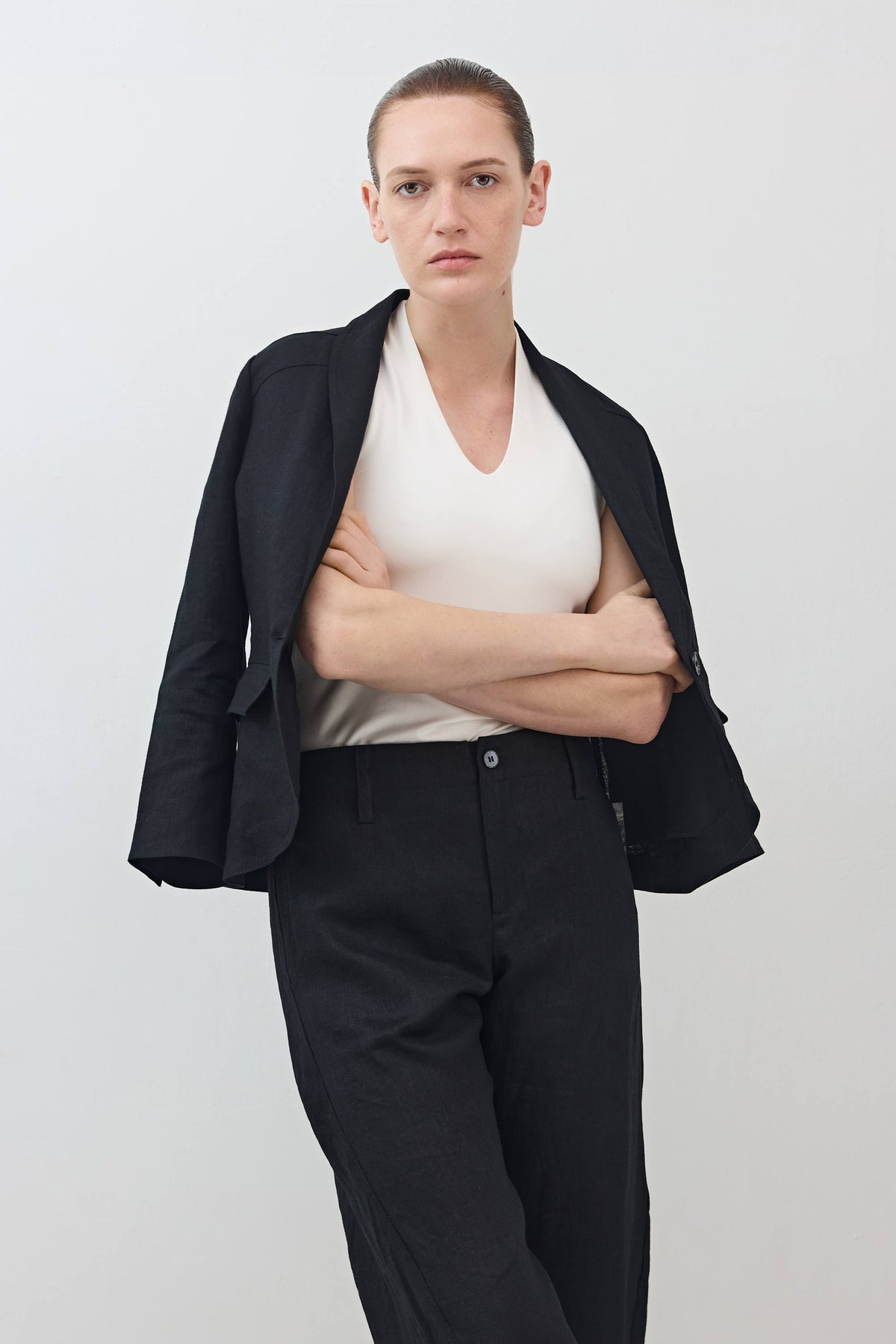 Black cropped blazer with notch lapels and flap pockets, single front button