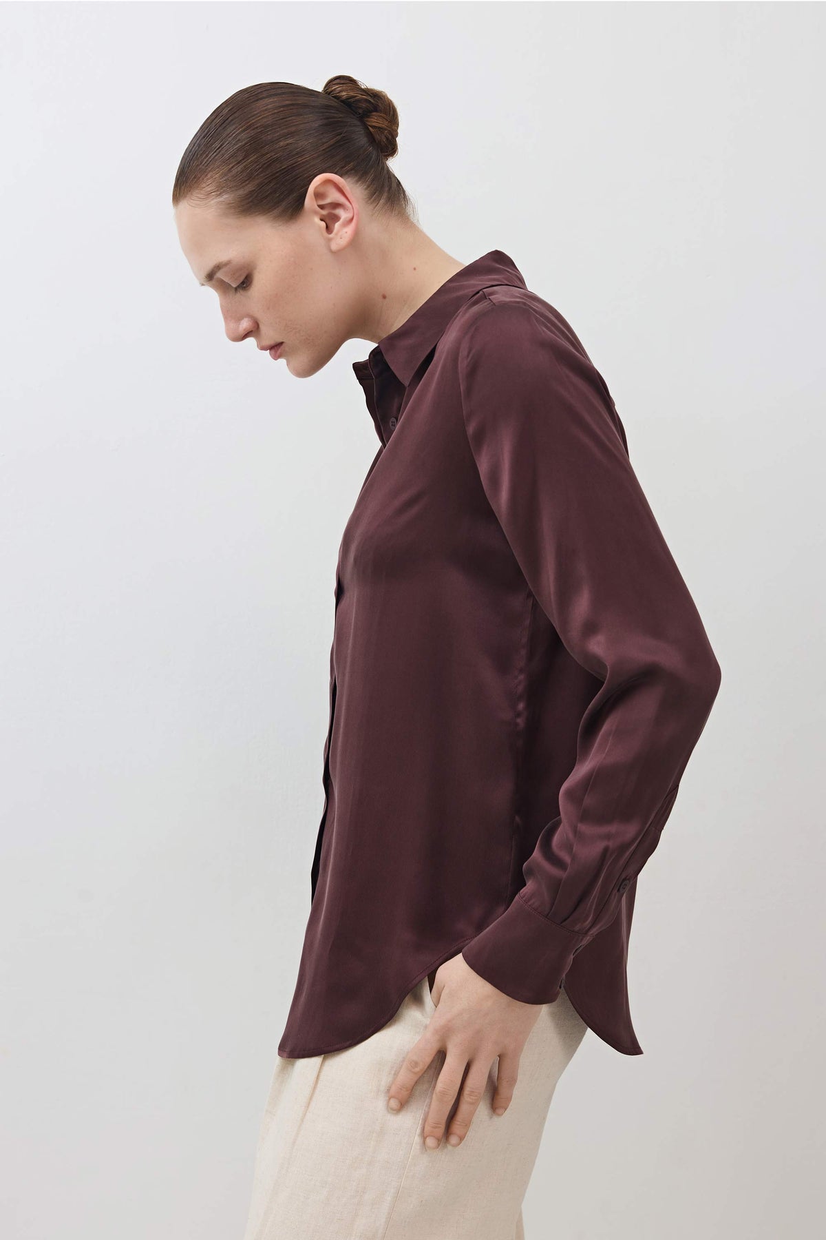 Dark plum silk button-down top with long sleeves and button front, side profile