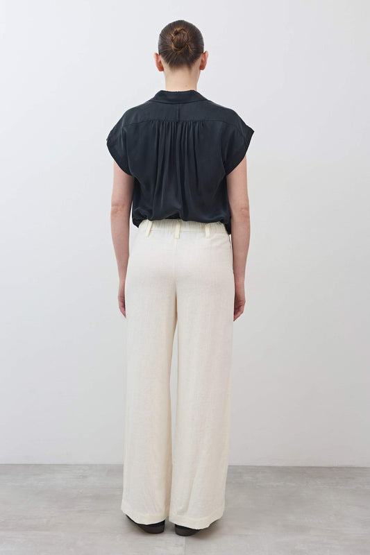 Ivory linen wide-leg trousers from back with high rise and straight wide legs