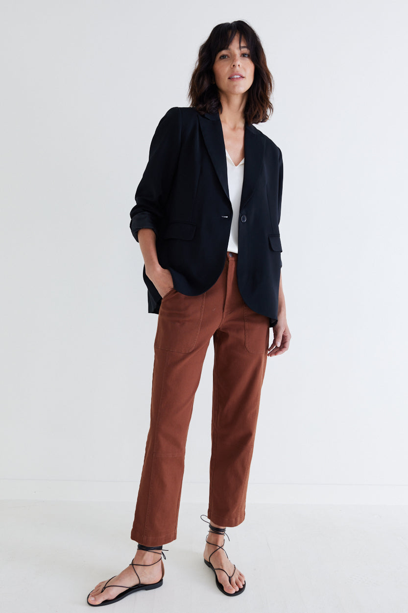 Classic black blazer worn over a white top with notch lapels and two front pockets