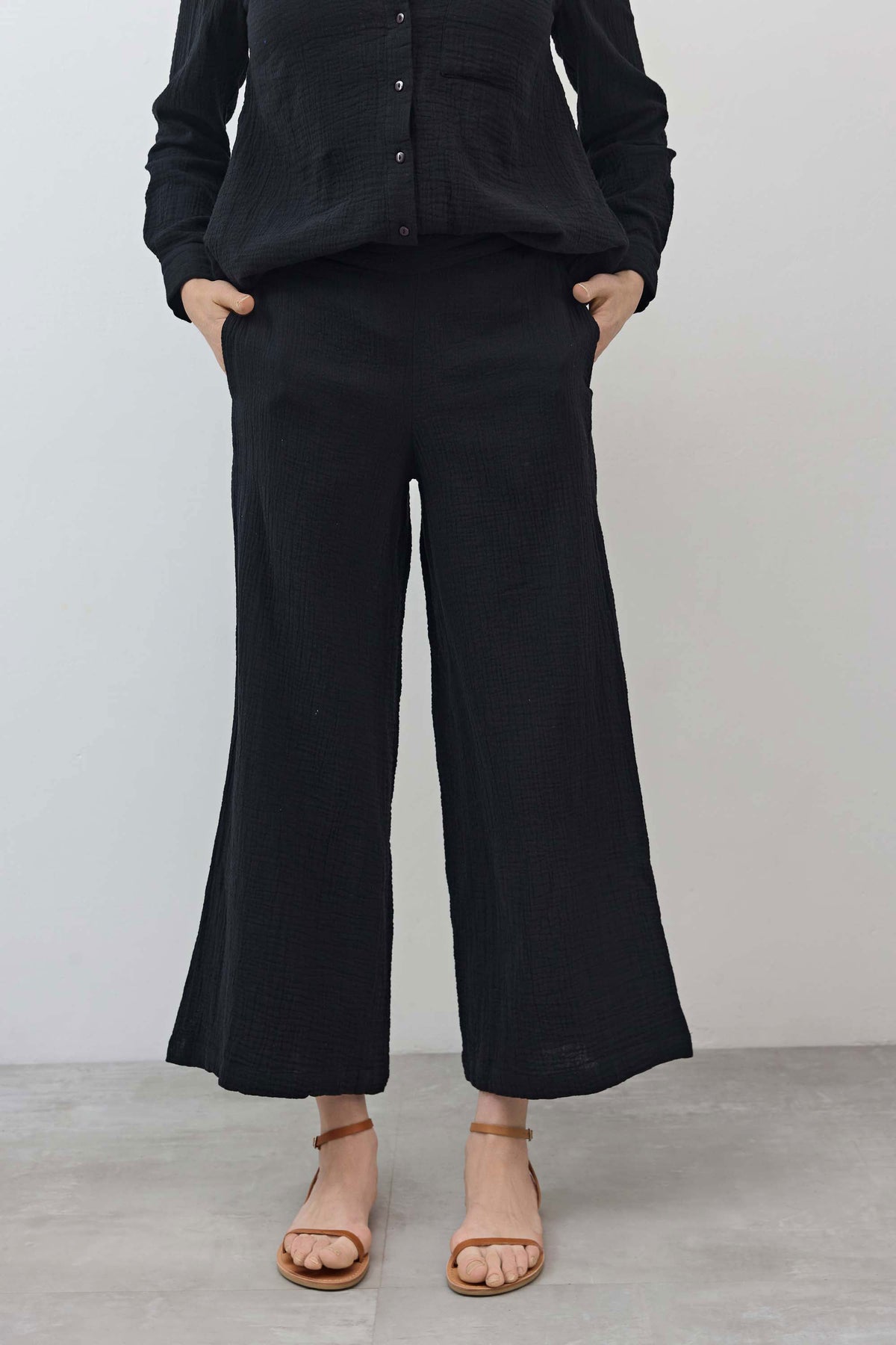 Black airy wide-leg pants with elastic waistband, textured finish, and wide leg opening