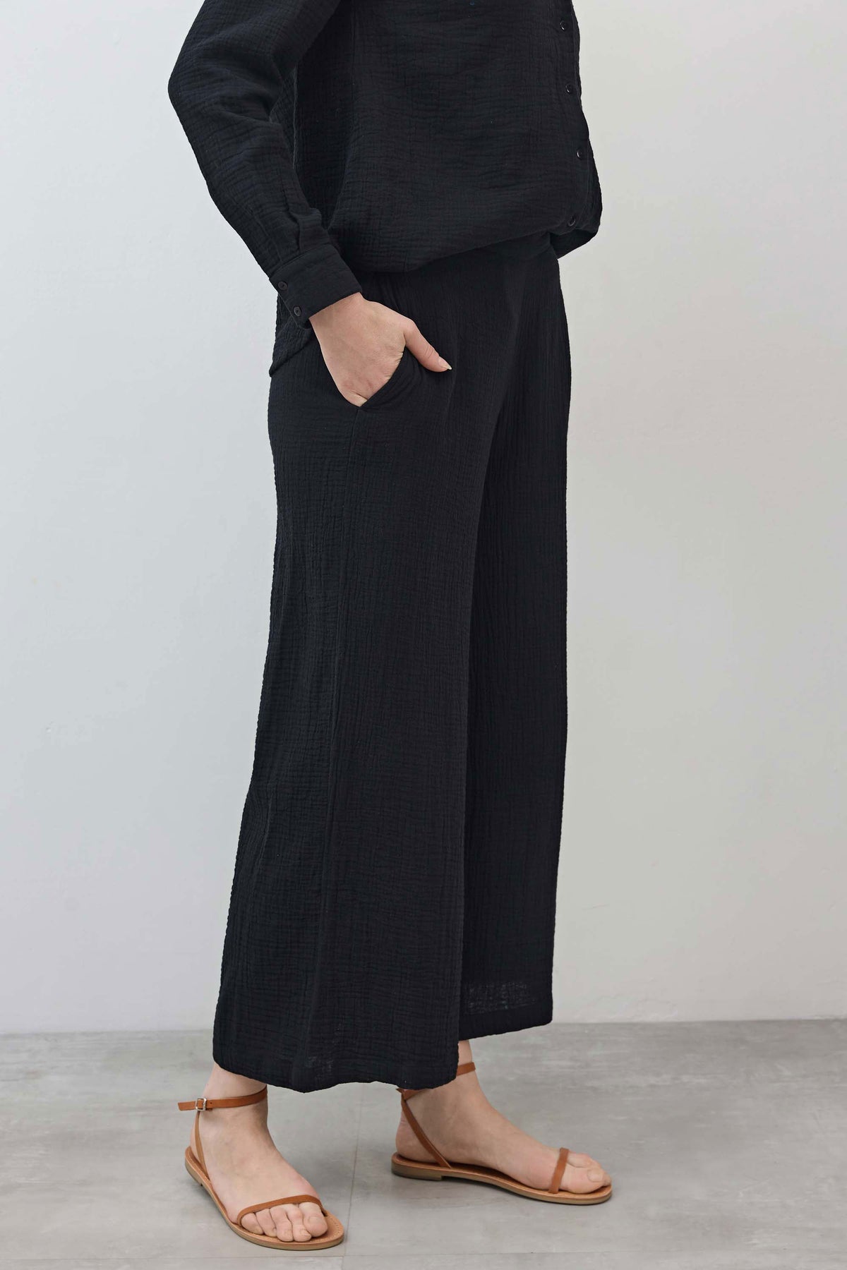 Black airy wide-leg pants with loose, textured weave and wide straight legs