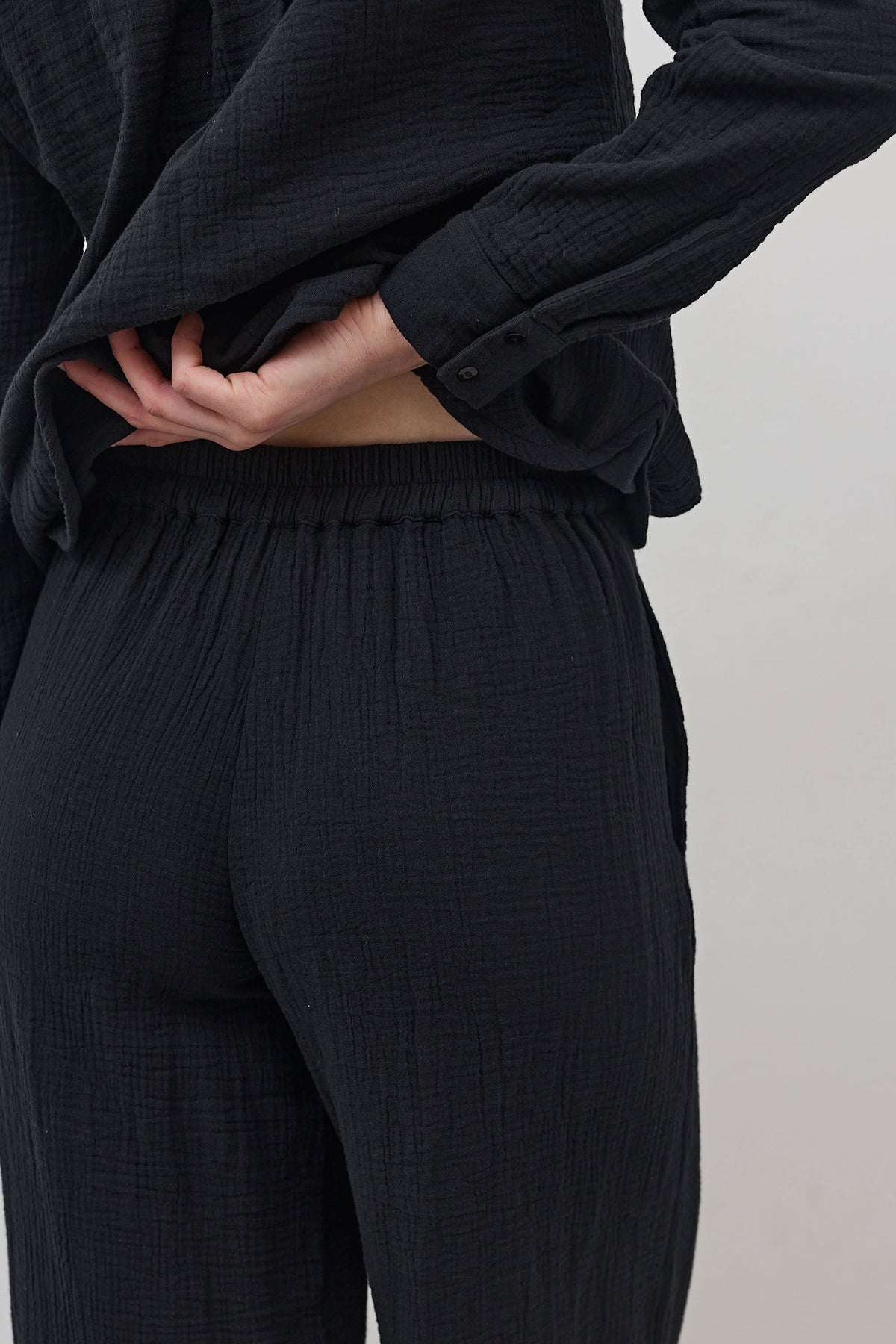 Black airy wide-leg pants with elastic waistband and gathered, textured fabric