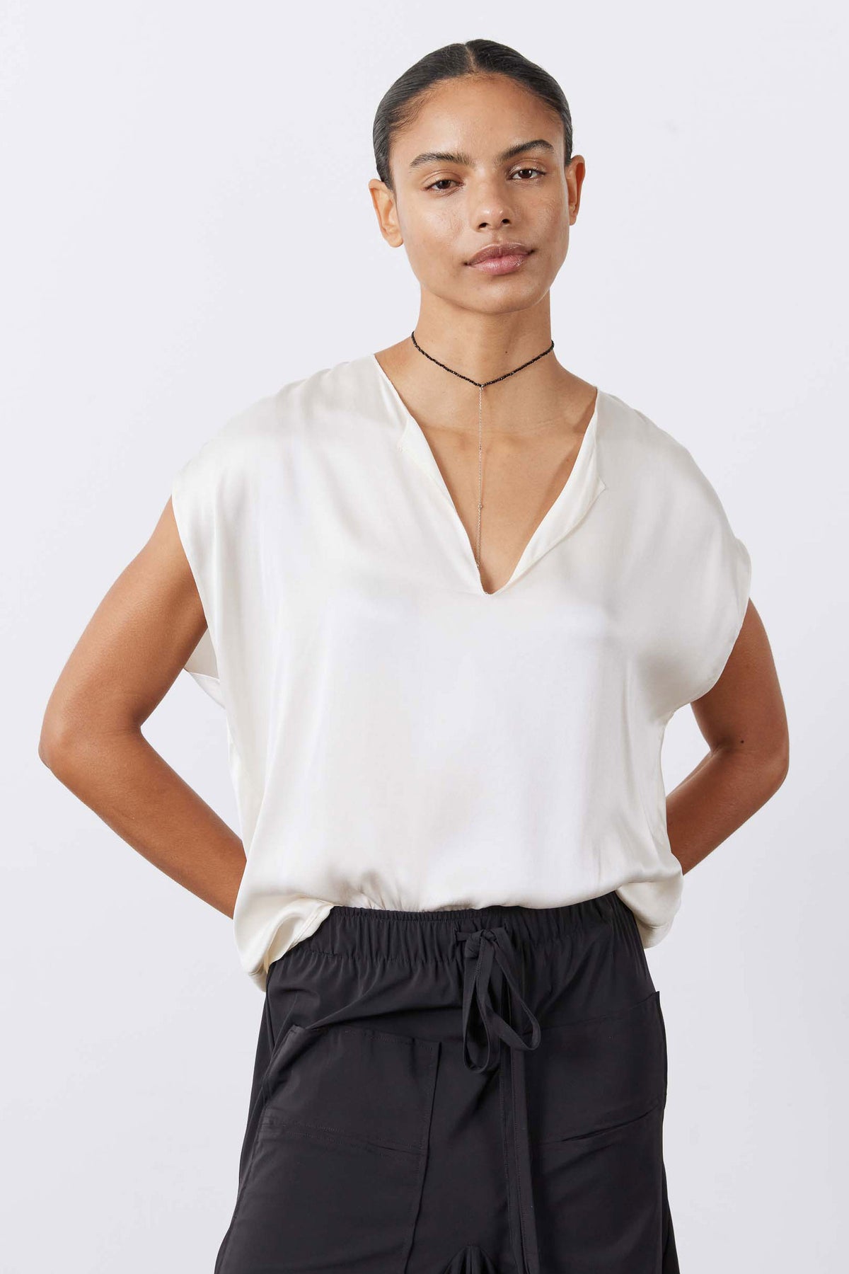 Cream silk V-neck sleeveless blouse with loose, relaxed silhouette