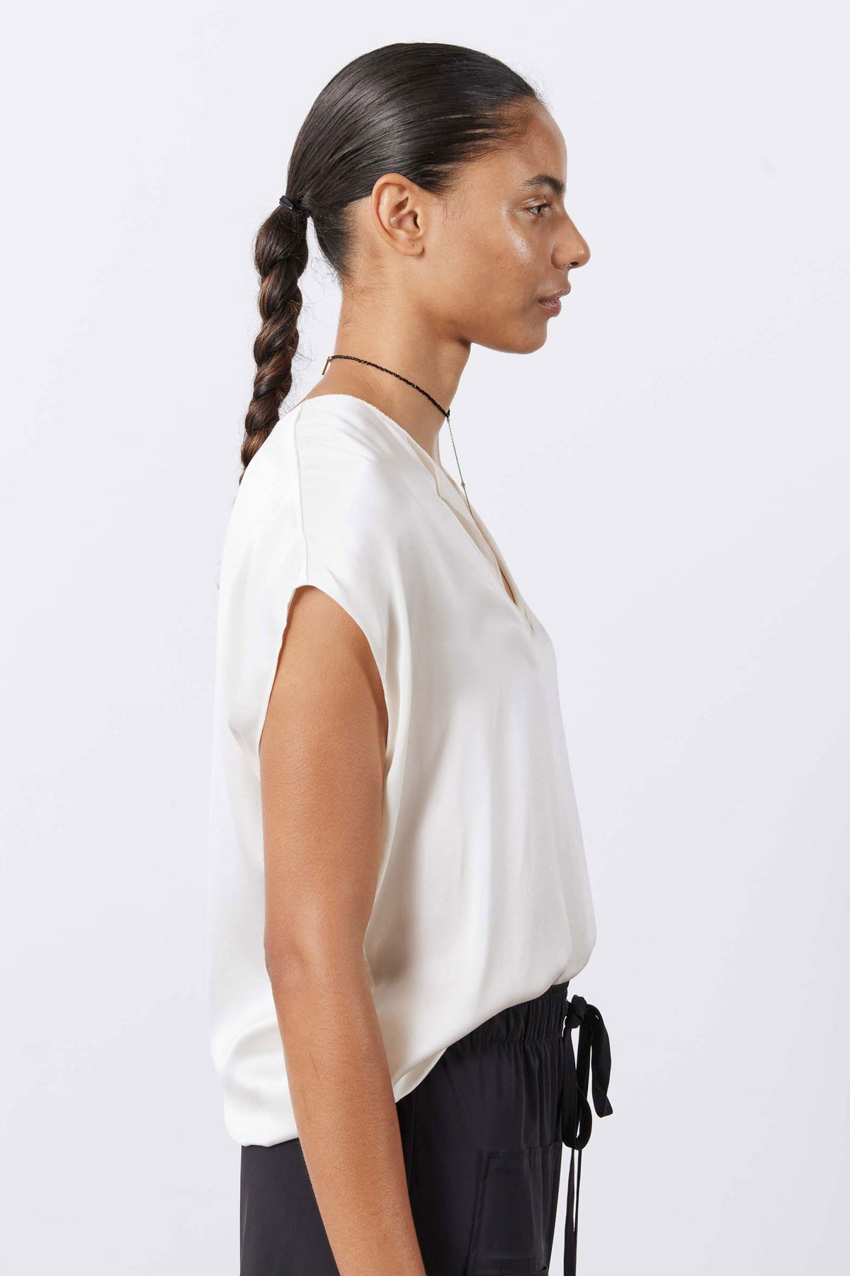 Cream silk V-neck sleeveless top on model, shown from the side