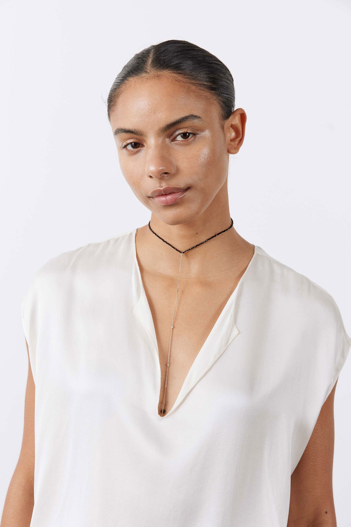 Cream silk sleeveless top with V-neck and softly gathered neckline