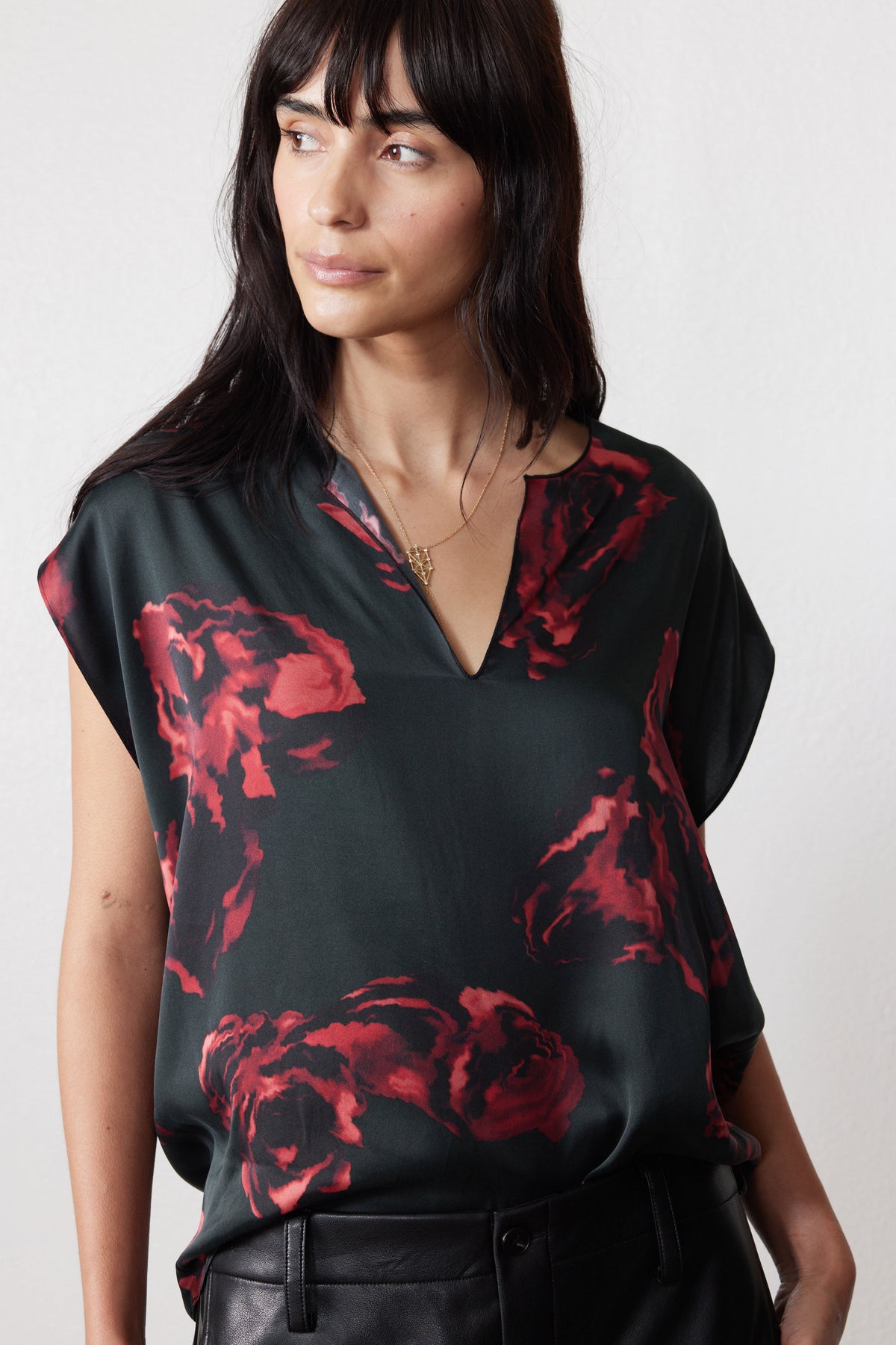 Close-up of rose-print silk top neckline, dark fabric with red floral pattern
