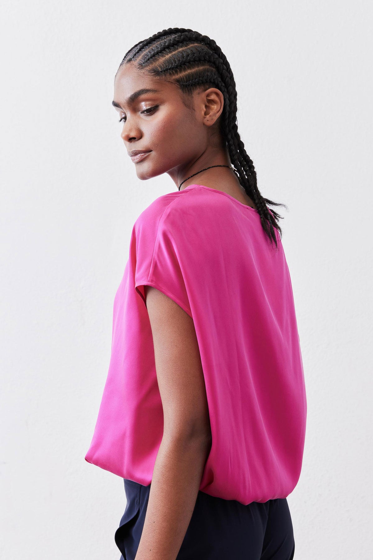 Fuchsia silk blouse with short sleeves and loose drape, side view