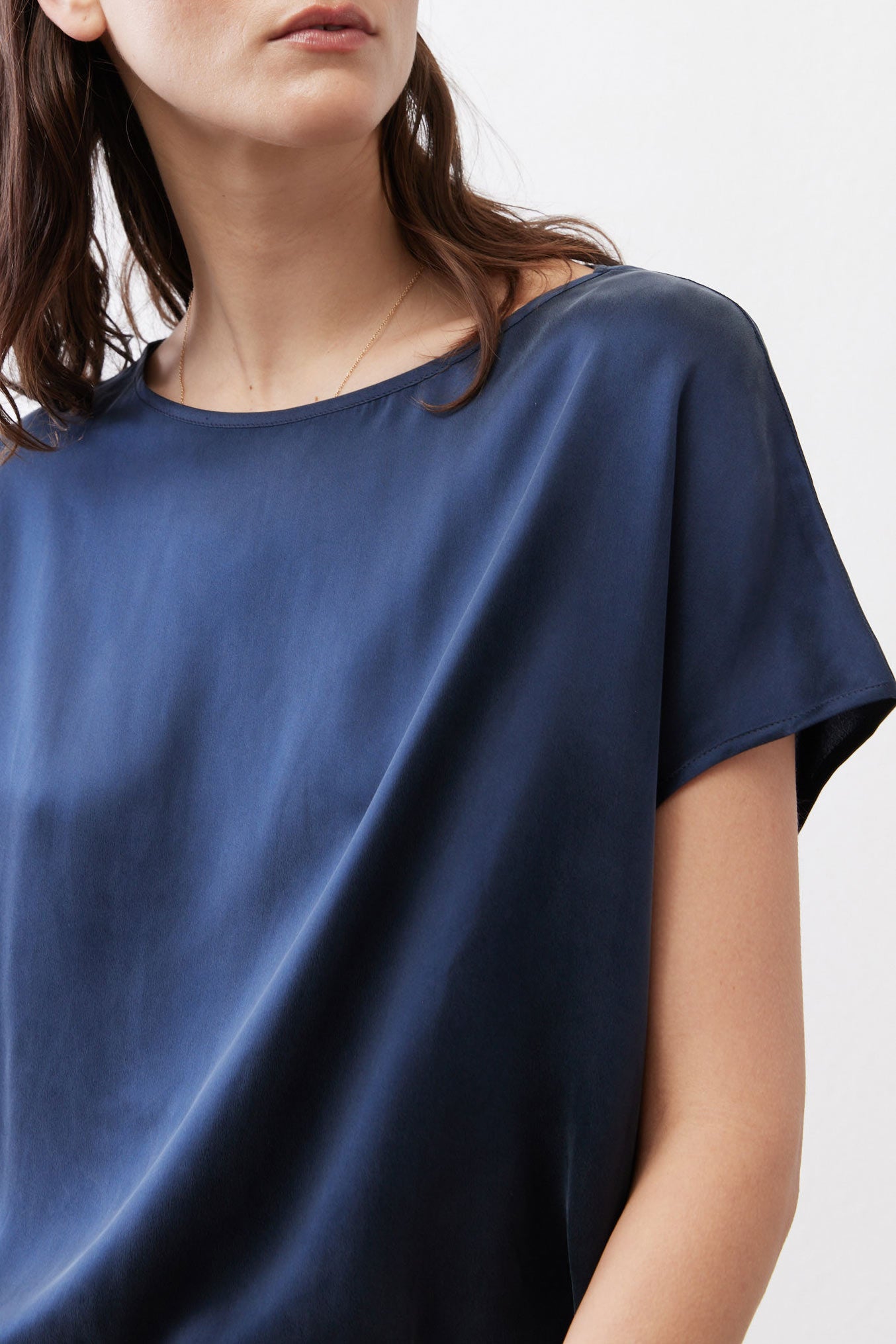 Close-up of deep blue silk blouse with crew neckline and short sleeves