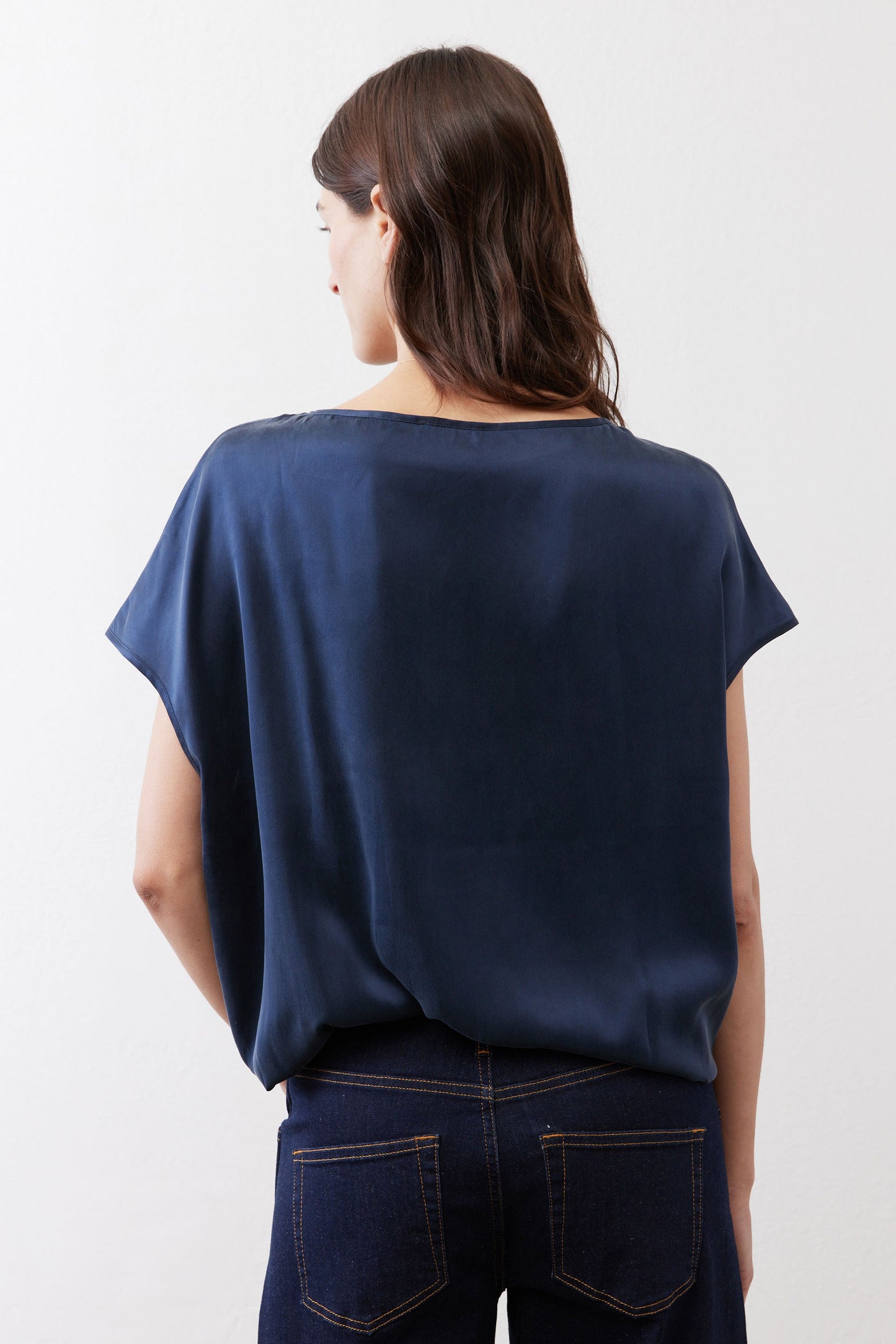 Back view of deep blue silk blouse with short sleeves and crew neckline