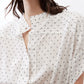 White button-front blouse with small black dot print and foldover collar