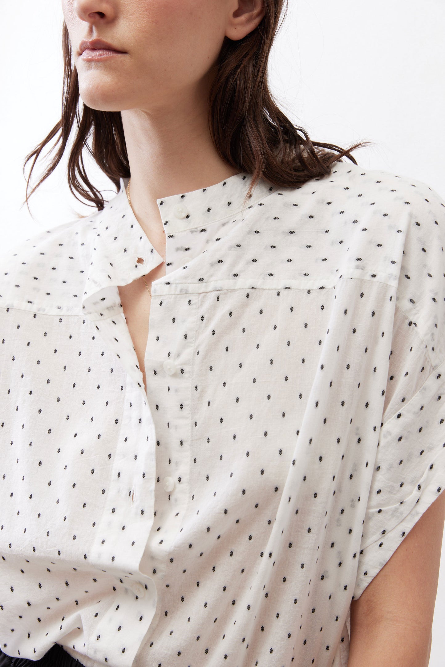White button-front blouse with small black dot print and foldover collar