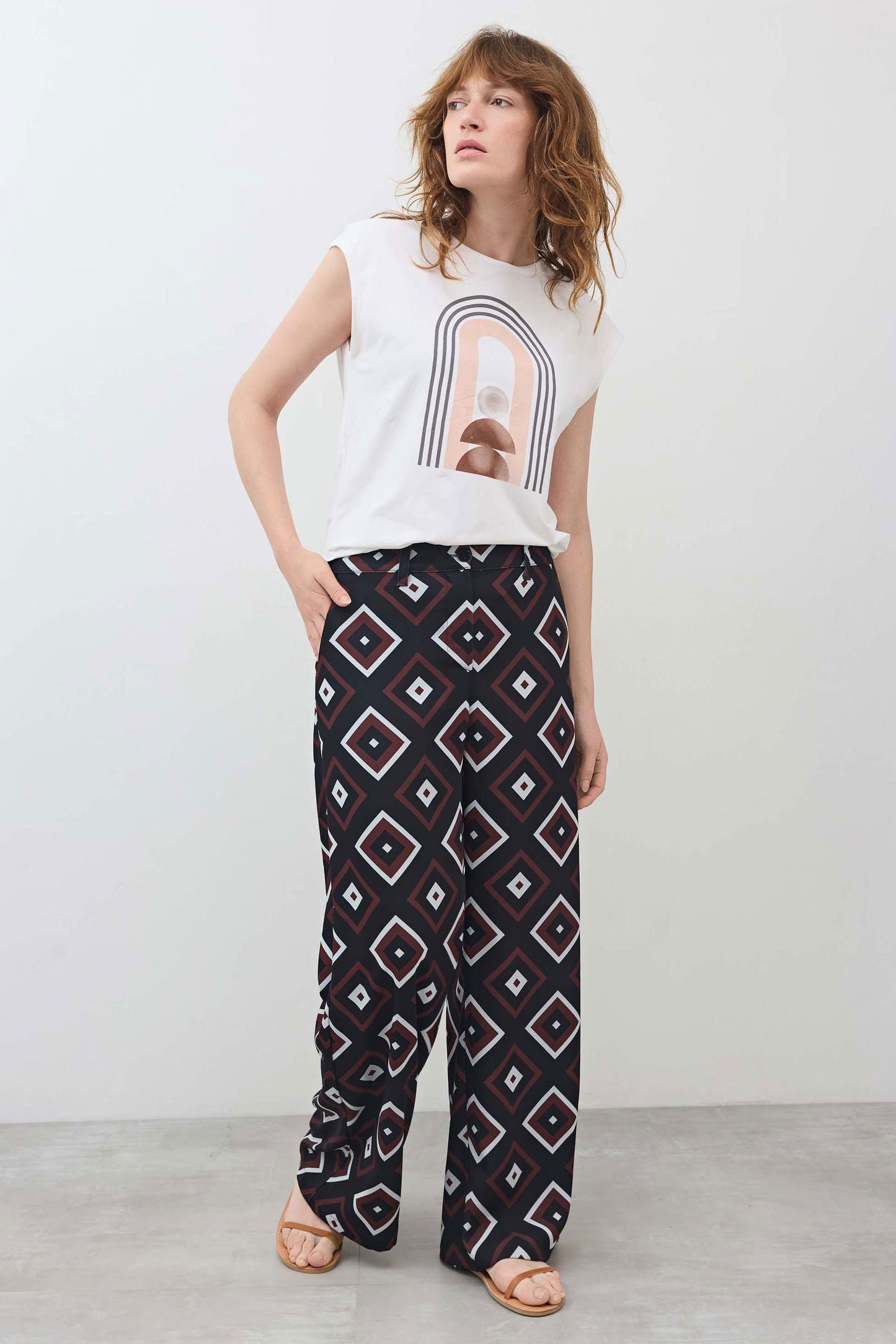 White sleeveless graphic tee with rainbow arch print at the front