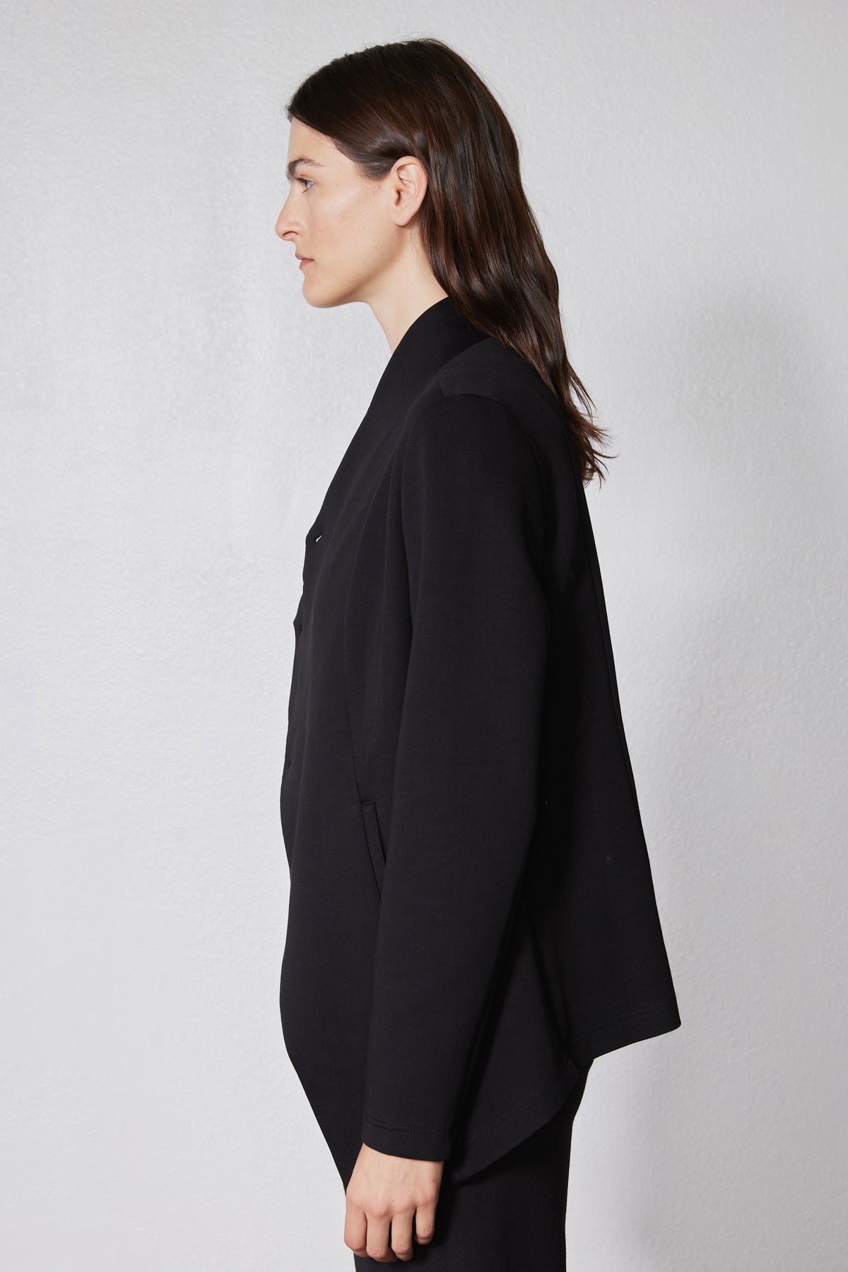 Black asymmetric scuba jacket with long sleeves and draped side panel detail