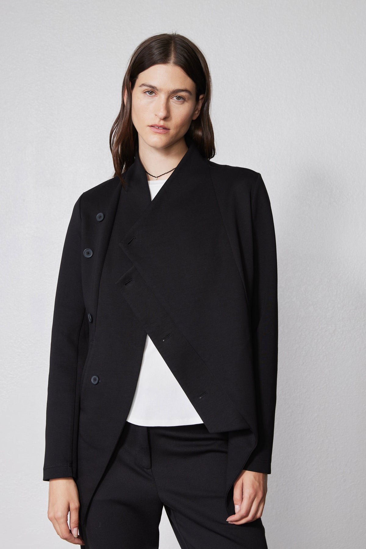 Black asymmetric scuba jacket with stand collar, snap buttons, and diagonal front panel
