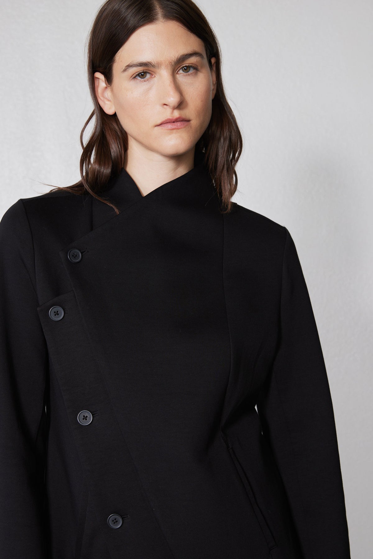 Black asymmetric scuba jacket close-up with stand collar and snap-button placket