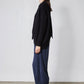 Black asymmetric pullover sweater side profile with diagonal wrap hem and crew neckline