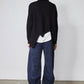 Black asymmetric pullover sweater back drape with diagonal seam and white layered hem