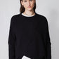 Black asymmetric pullover sweater with ribbed crew neck trim and overlapping diagonal front