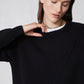 Black asymmetric pullover sweater with ribbed crew neck and diagonal front seam