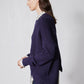 Asymmetric pullover sweater in deep purple, side view with diagonal panel and ribbed cuffs