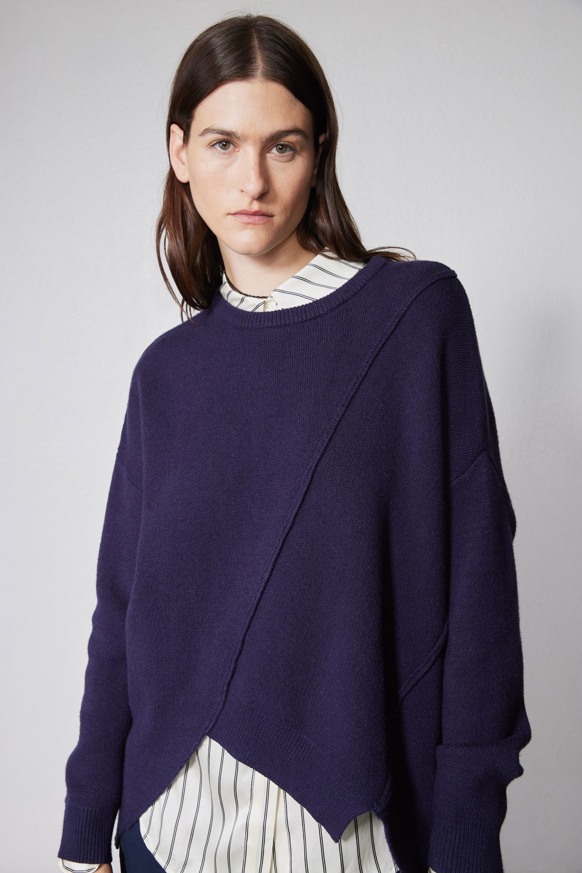 Asymmetric pullover sweater in deep purple, front view with wide cuffs and diagonal drape