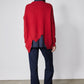 Back view of red asymmetric pullover sweater with angled seam across shoulders