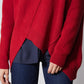 Red asymmetric pullover sweater close-up; ribbed cuffs and angled hem panel