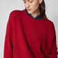Red asymmetric pullover sweater close-up with crew neck ribbing and diagonal seam
