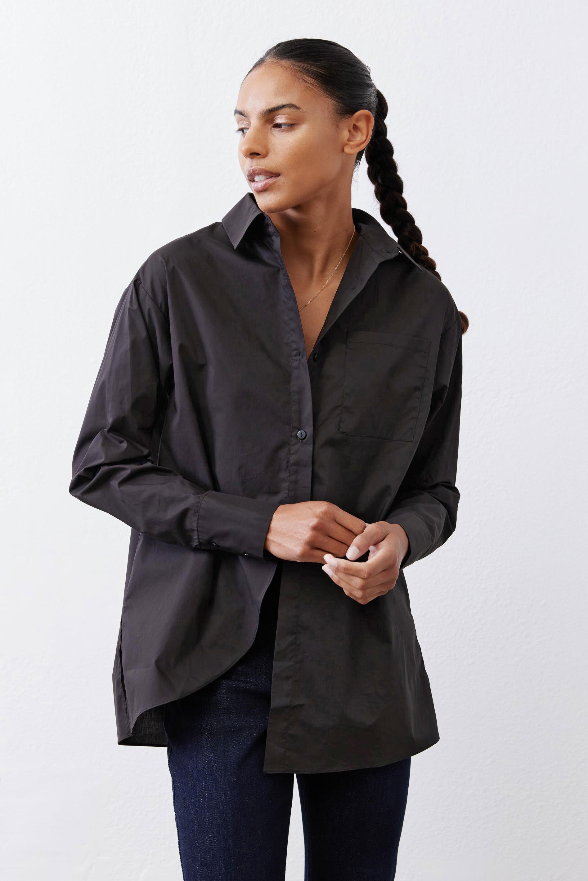Black asymmetric button-down shirt detail: collar and front button placket