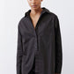Black asymmetric button-down shirt with chest pocket and front button closure