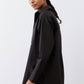 Black asymmetric button-down shirt side profile with relaxed straight sleeves