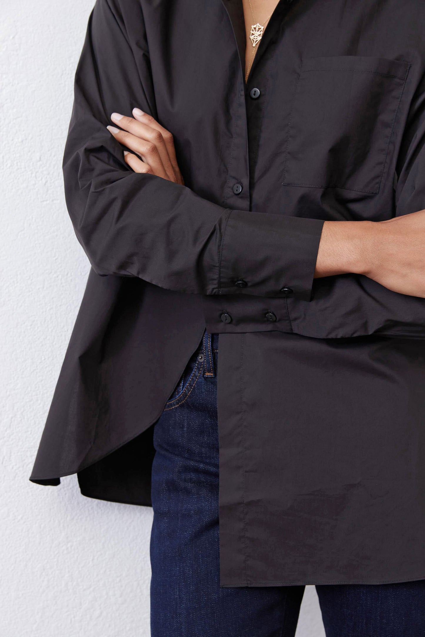 Black asymmetric button-down shirt front placket and curved hem detail
