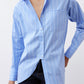 Close-up of light blue striped button-down shirt front with V-neck opening