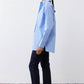 Side view of light blue and white striped button-down shirt, asymmetric hem