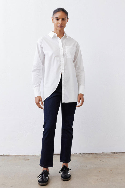 White asymmetric button-down shirt with pointed collar, long sleeves, front split