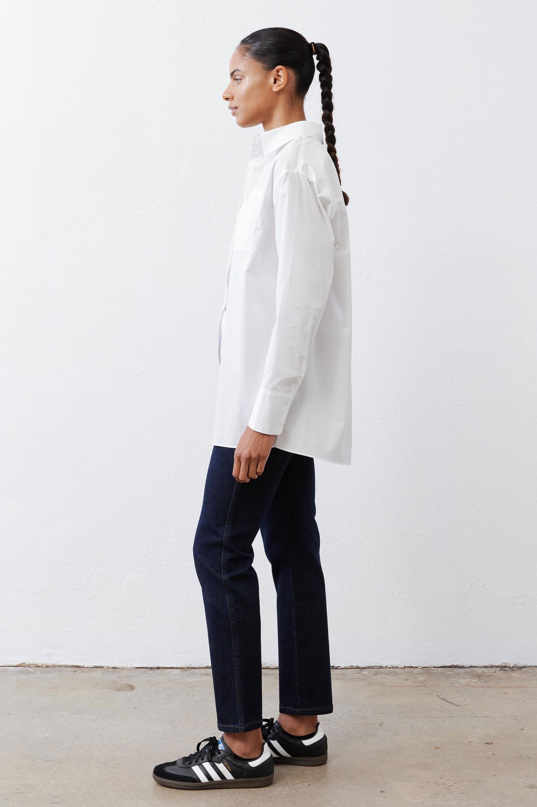 White asymmetric button-down shirt, long sleeves and pointed collar, side profile