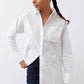 White asymmetric button-down shirt with pointed collar and long sleeves, tucked front