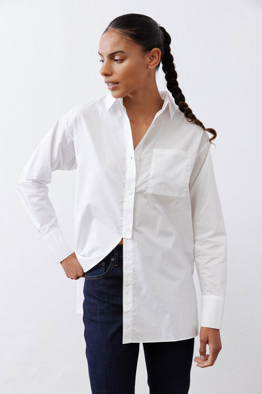 White asymmetric button-down shirt with pointed collar and long sleeves, tucked front