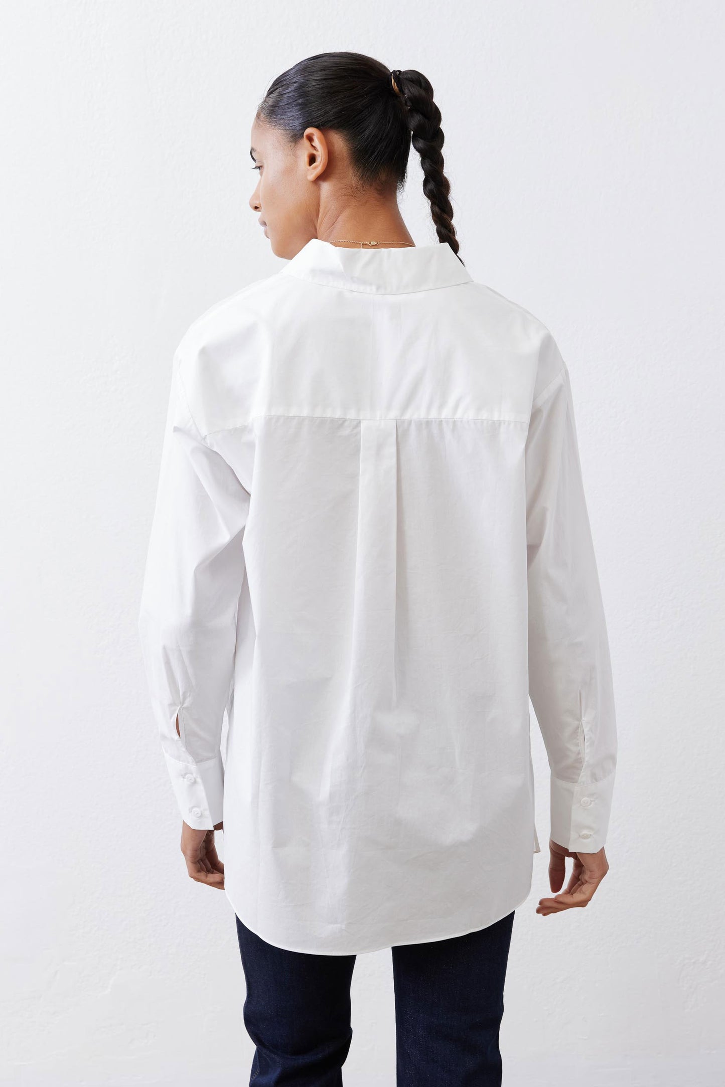White asymmetric button-down shirt from back, long sleeves and pointed collar