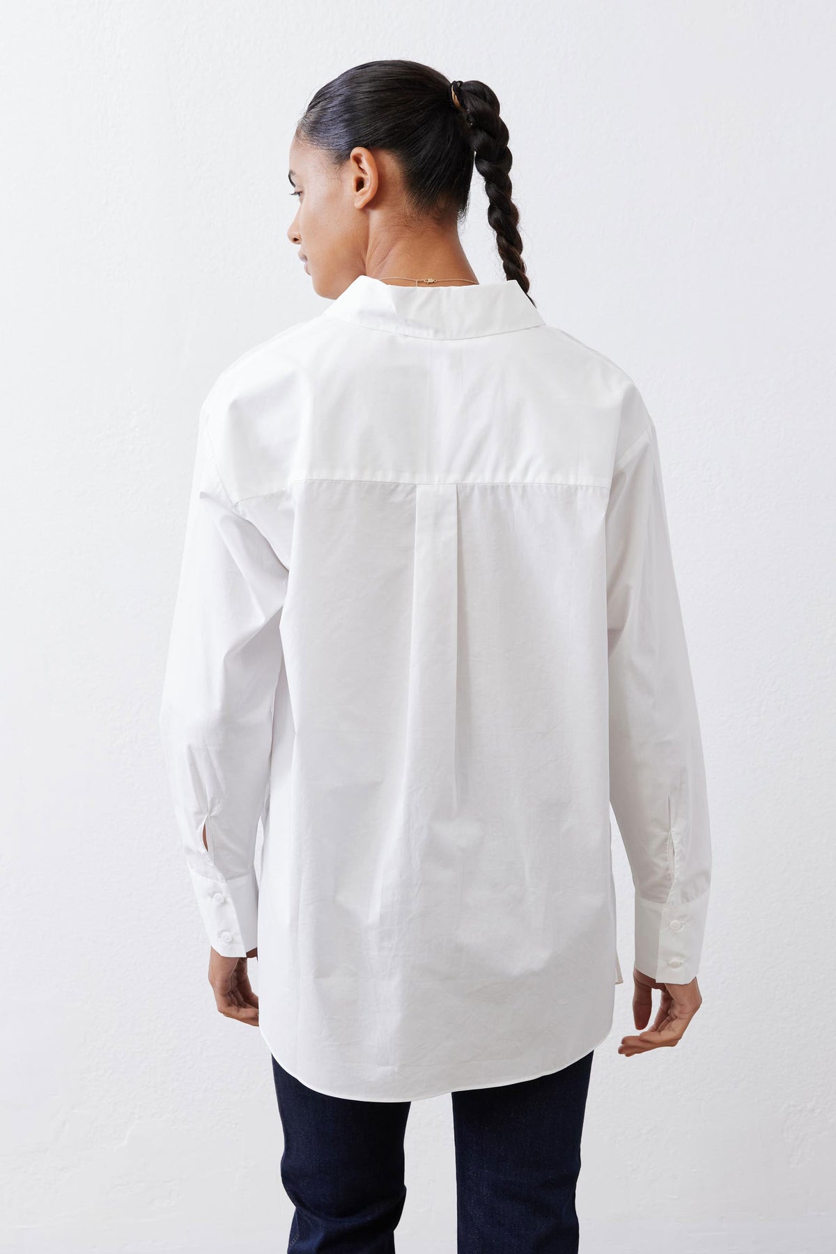White asymmetric button-down shirt from back, long sleeves and pointed collar
