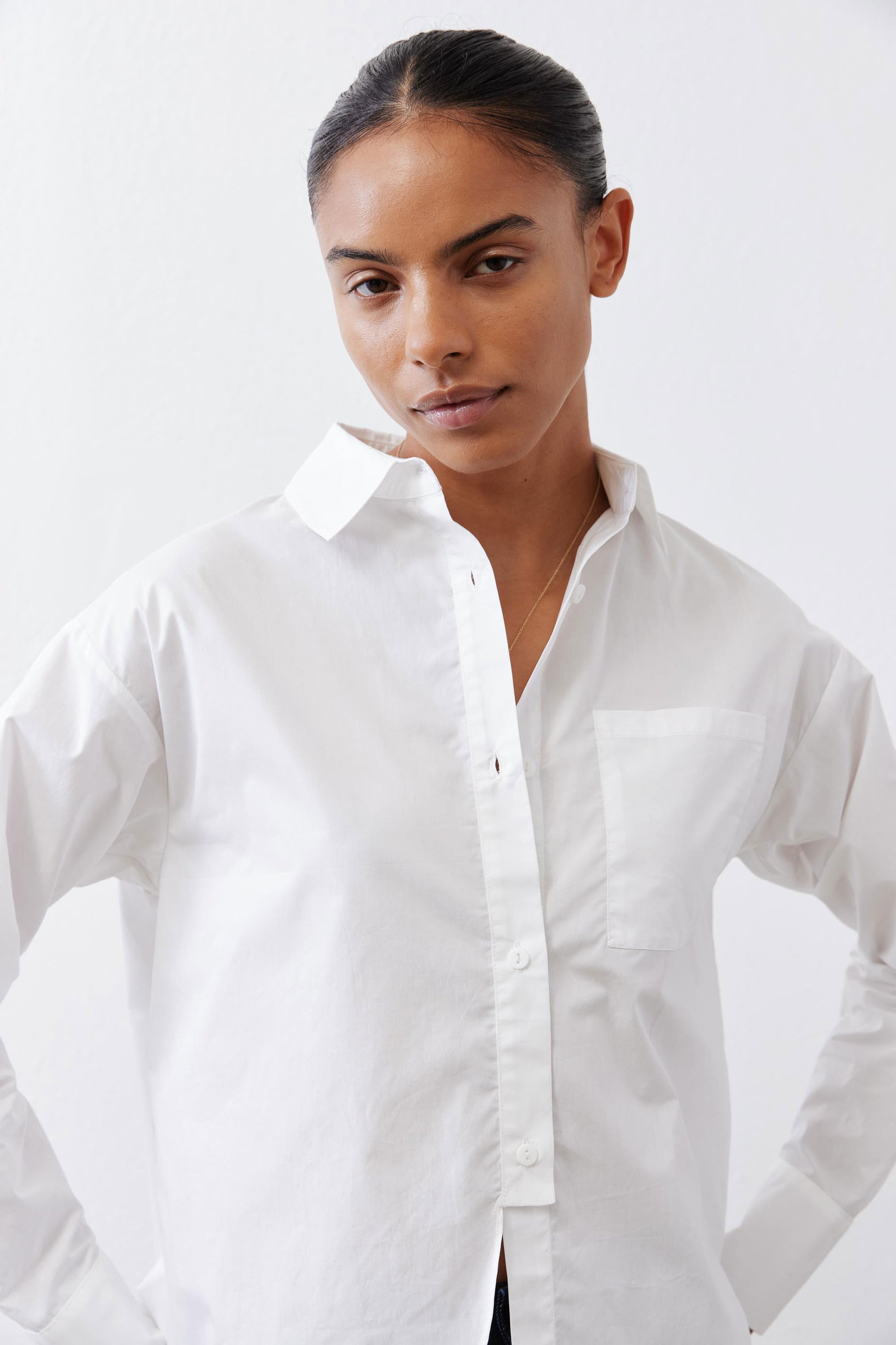 White asymmetric button-down shirt with pointed collar, front buttons and chest pocket