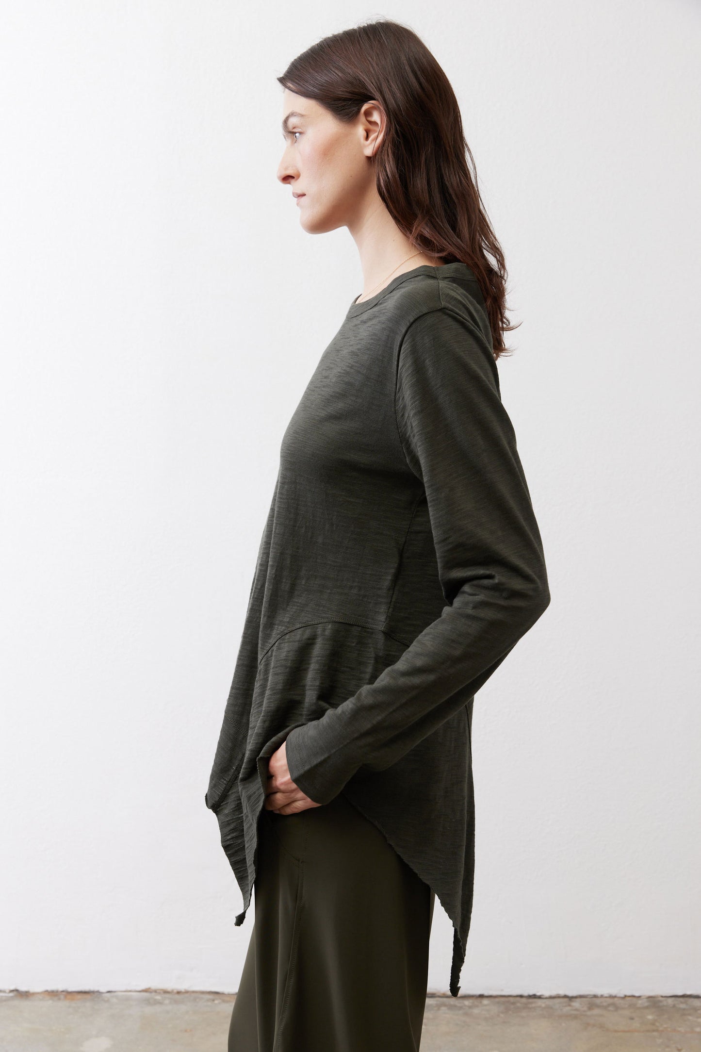 Asymmetric long-sleeve tunic in dark forest green with side split and curved hem