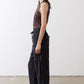 Black baggy utility pants in side profile with elastic waist, drawstring ties, wide legs