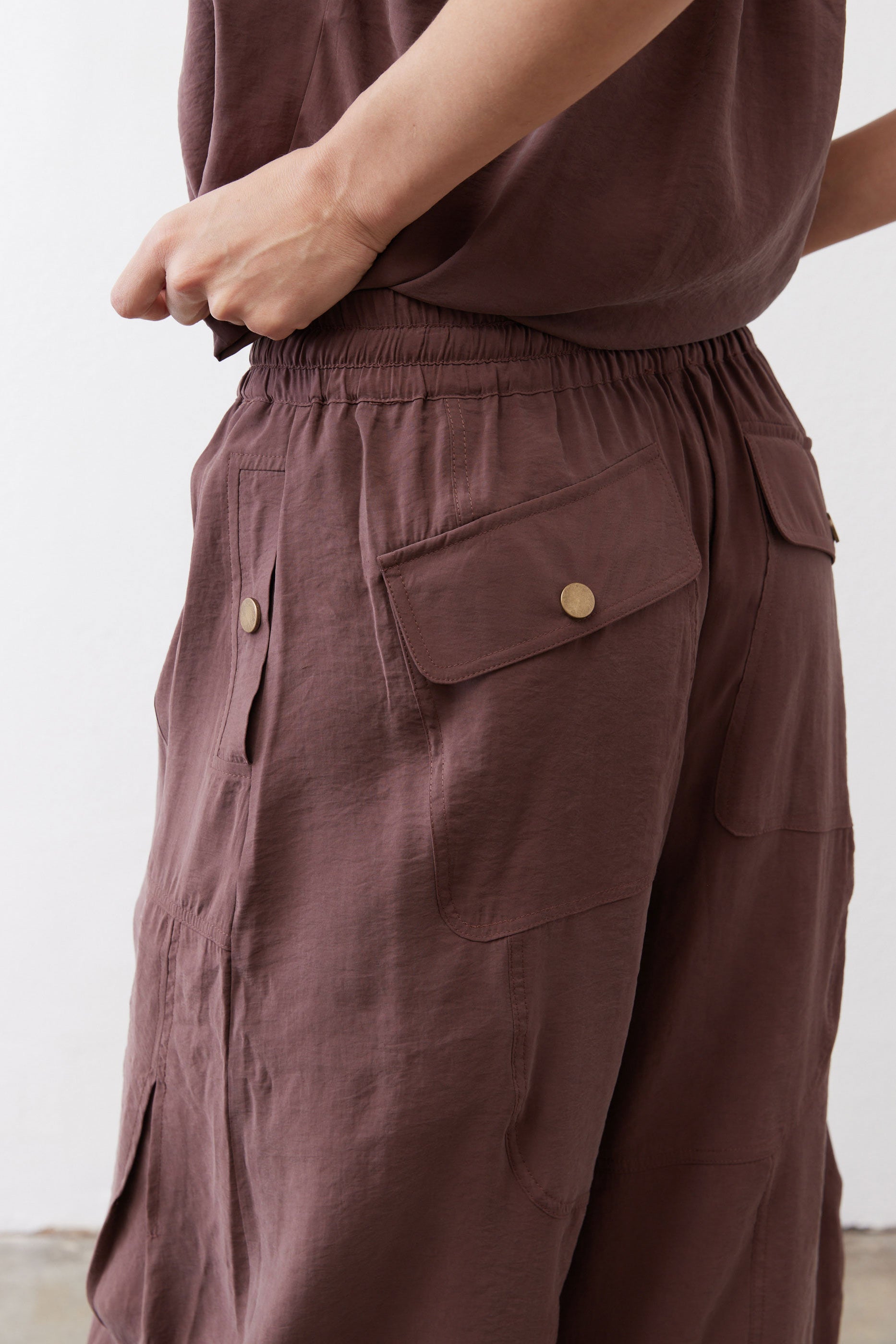 Chicory coffee utility pants with front cargo pocket and brass-look button tabs