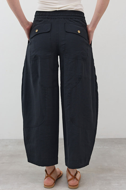 Baggy utility pants with back flap pockets, elastic waist, relaxed cropped-leg silhouette.