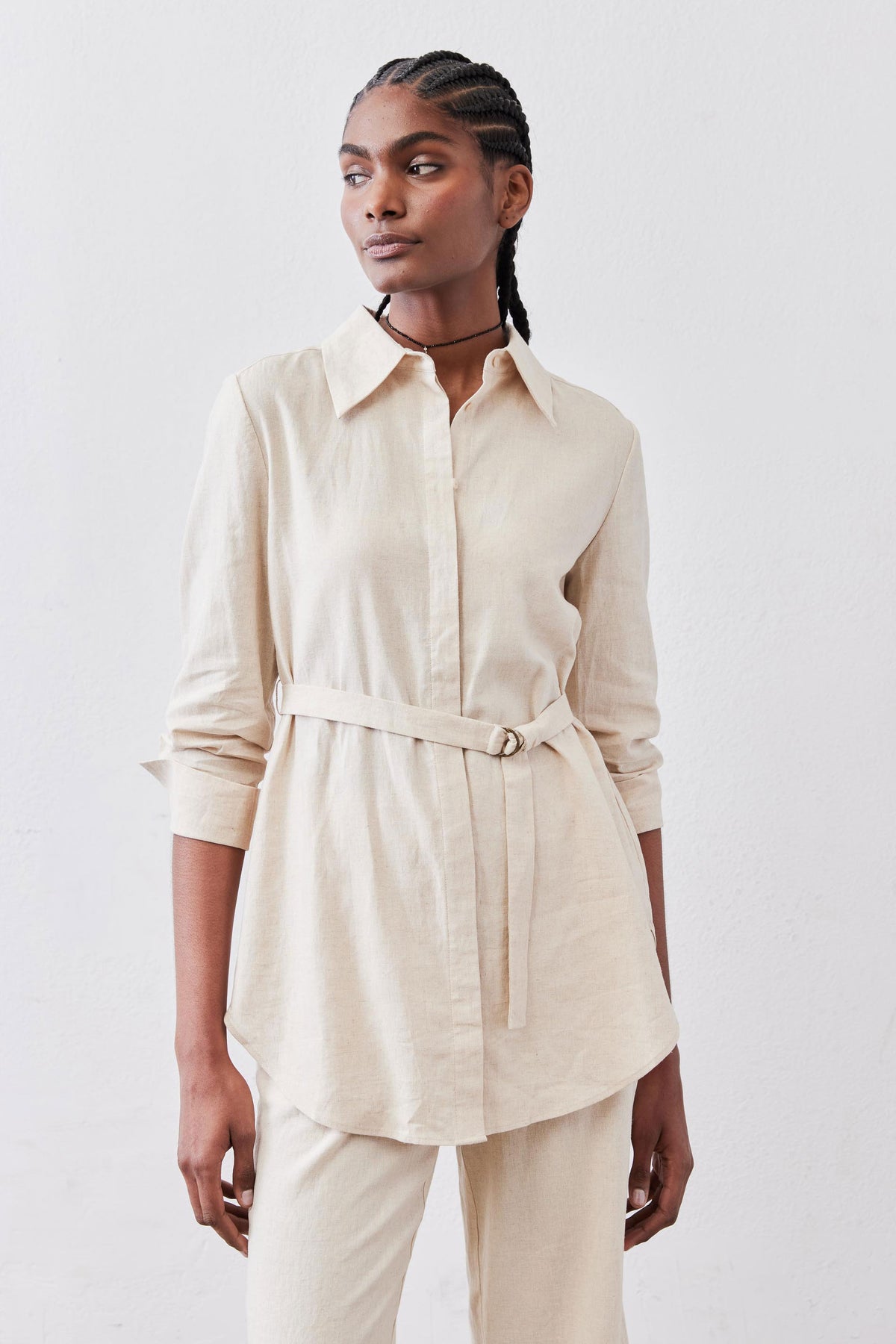 Oat linen belted tunic with button-front, pointed collar, and self-tie waist belt.