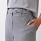 Close-up of belted pebble melange gray trousers with metal buckle and front pocket